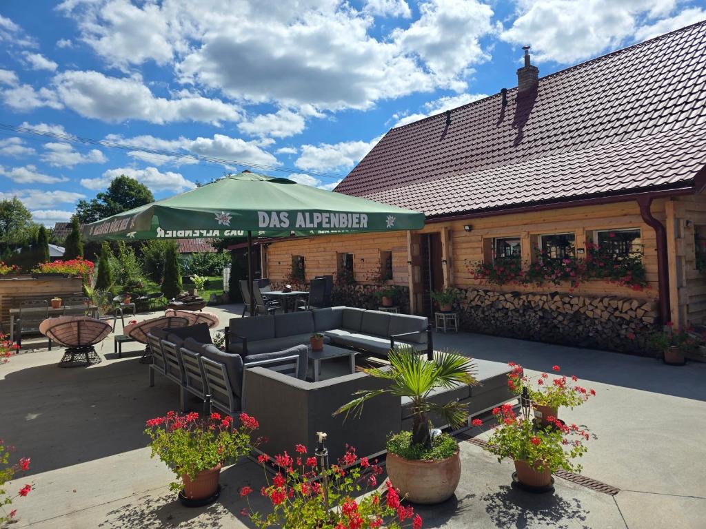 a restaurant with a green umbrella and chairs and flowers at Beskydy Areal in Prostřední Bečva