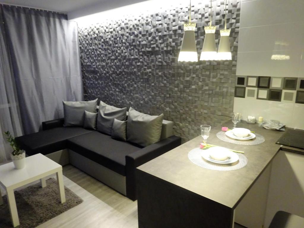 a kitchen and a living room with a couch and a table at Apartament Junior in Warsaw