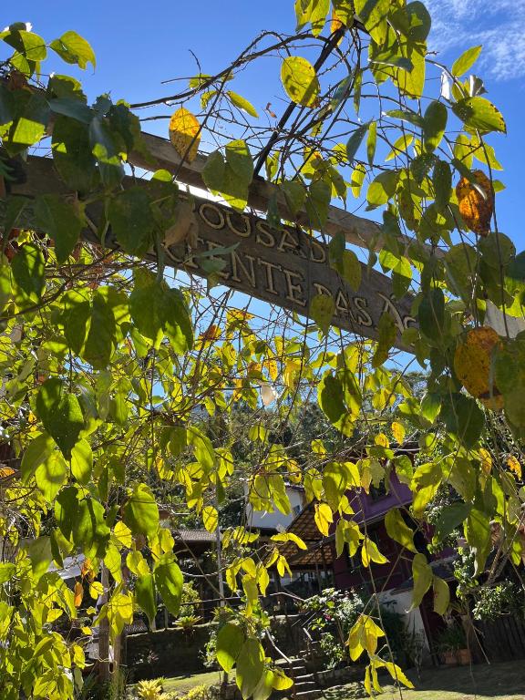 a sign that reads garden entrance behind some trees at Pousada Vertente das Águas in Lumiar