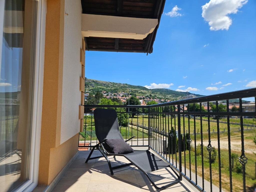 a chair on a balcony with a view at Garden Haus Livno in Livno