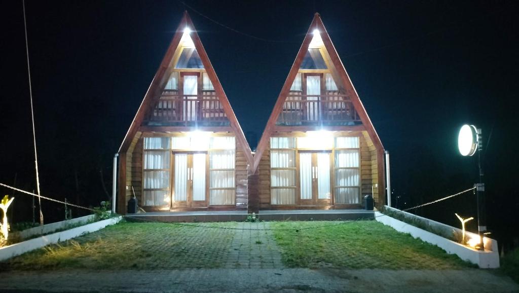 a wooden house with three pointed roofs at night at The Aisyah Cabin in Wonosobo