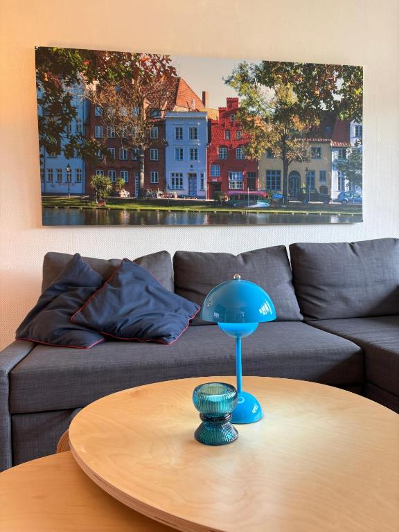 a blue lamp on a table in front of a couch at Hotel Am Mühlenteich in Lübeck