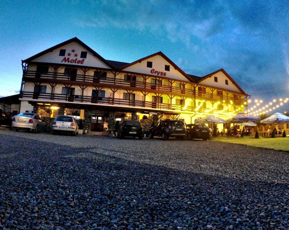 a large building with cars parked in front of it at motel cryss in Ocna Sibiului