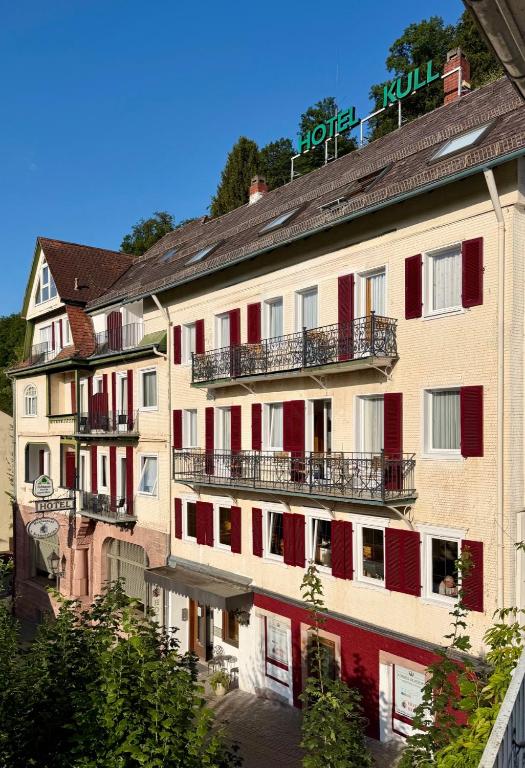 a large building with red doors and balconies at Hotel Kull von Schmidsfelden in Bad Herrenalb