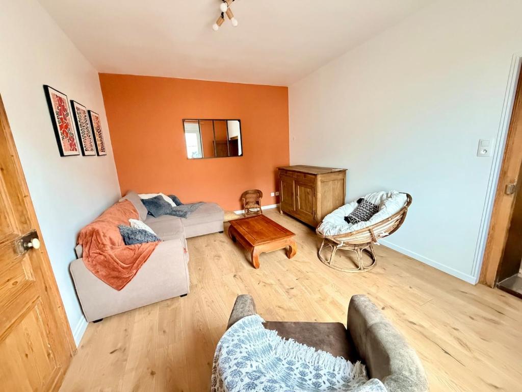 a living room with a couch and a chair at Gite Maison Saint-Martin in La Groise