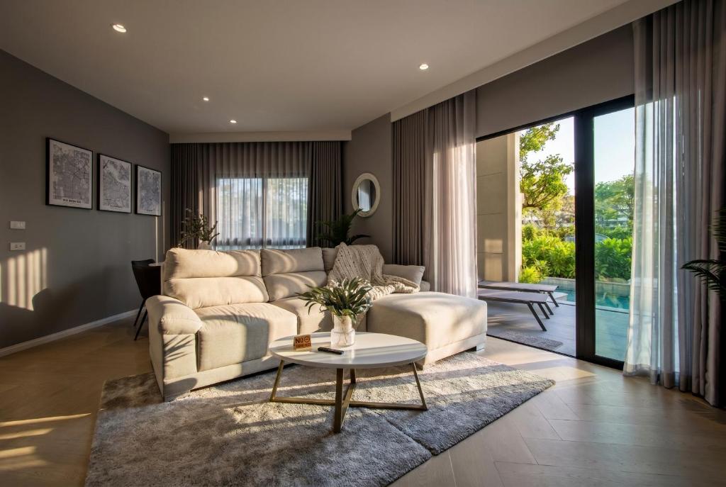 a living room with a couch and a table at Luxury 2 bedroom pool access apartment in Bang Tao Beach