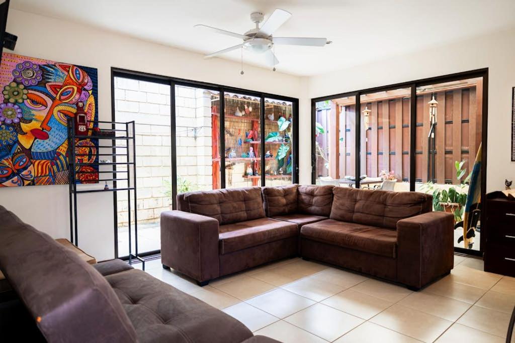 a living room with a couch and a ceiling fan at Casa Villa Ensueño in Jacó