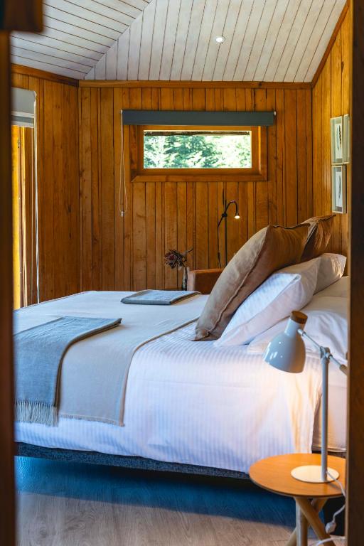 a bedroom with a large bed and a window at Peuma Lodge Patagonia in Futaleufú