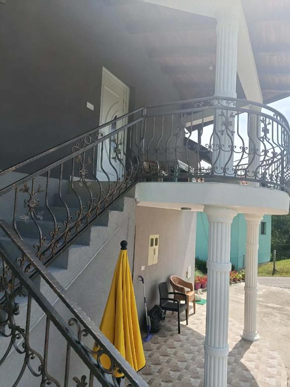 ein Balkon mit Wendeltreppe und gelben Sonnenschirmen in der Unterkunft Harmony Haus in Visoko