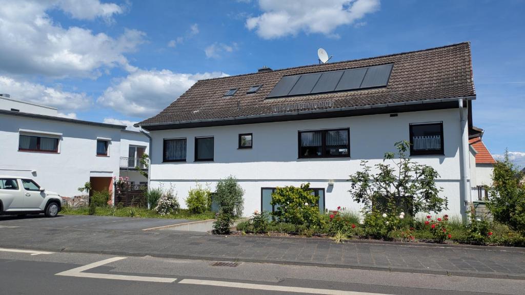 a white house with a solar panel on the roof at Ferienapartment Erdmann in Münster