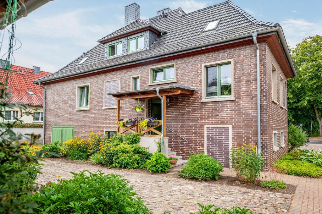 a brick house with a garden in front of it at Pension Pusteblume in Meyenburg