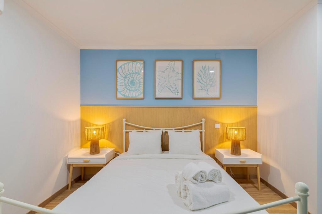 a bedroom with a white bed with two nightstands and two lamps at Bocage Blue Heaven I, By Home Match in Setúbal