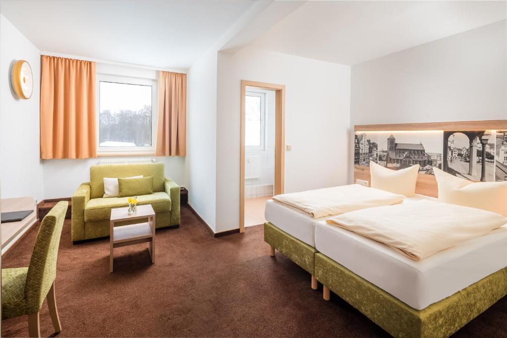 a hotel room with a bed and a couch at Lübsche Thorweide in Wismar
