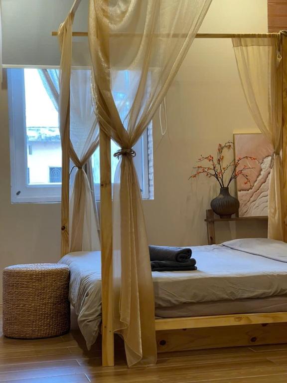 a bedroom with a canopy bed with a window at The Miá home in Can Tho