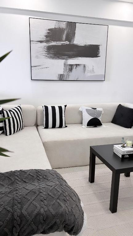 a living room with a white couch and a table at Skyline Westlands with Gym in Nairobi
