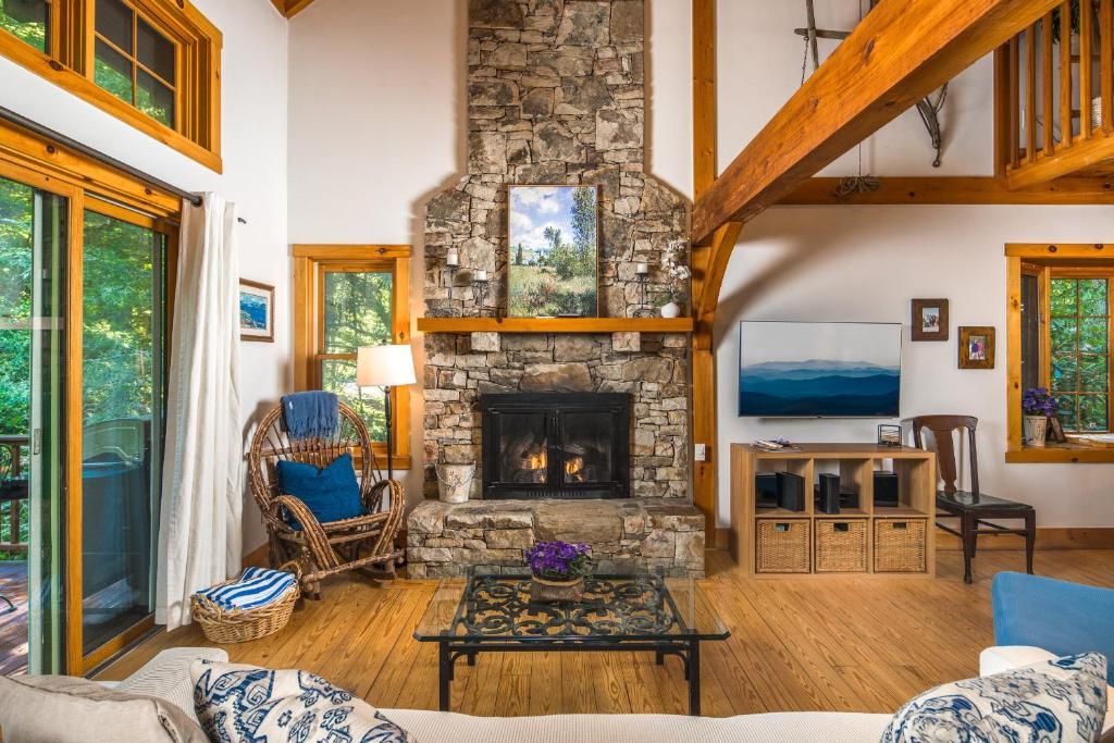 a living room with a stone fireplace at Waterfall Cottage in Boone