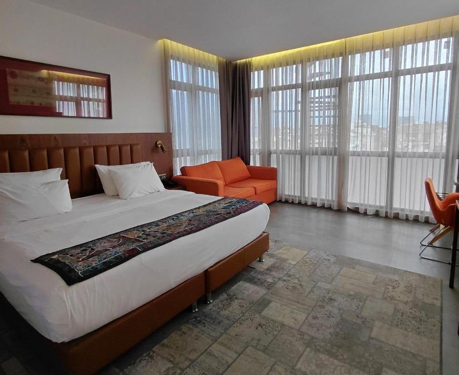 a bedroom with a large bed and an orange chair at Numi Hotel in Istanbul