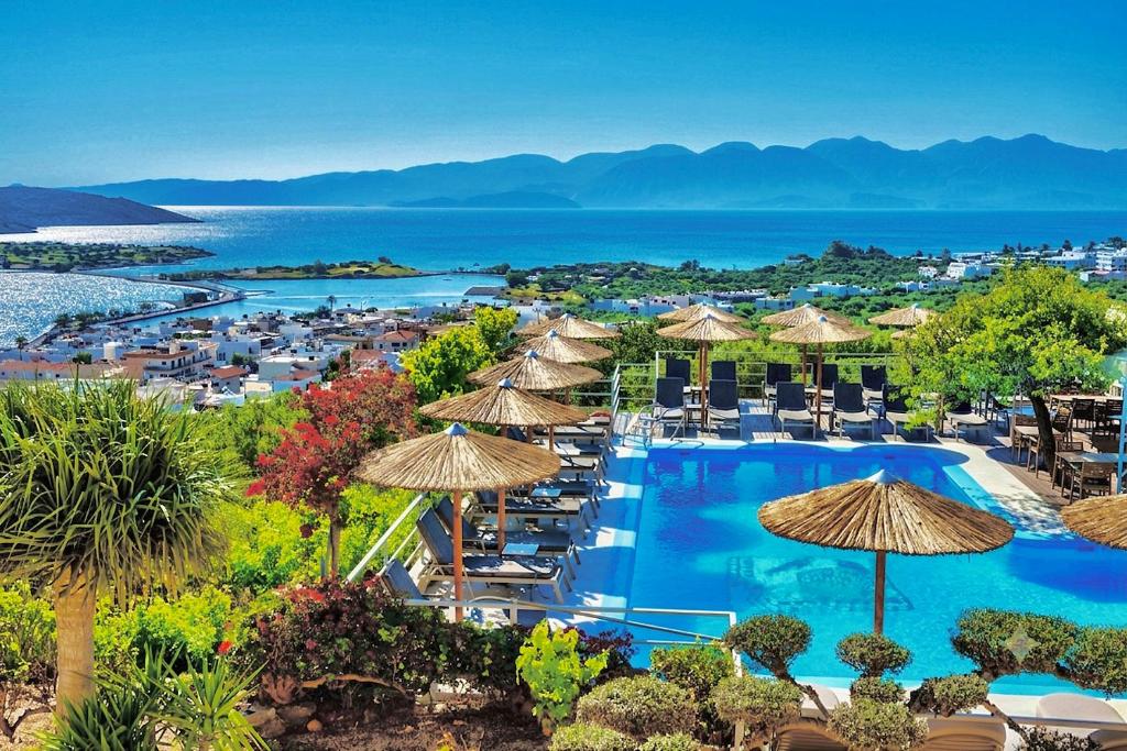 a resort with a pool and chairs and umbrellas at Elounda Heights (Adults Only) in Elounda