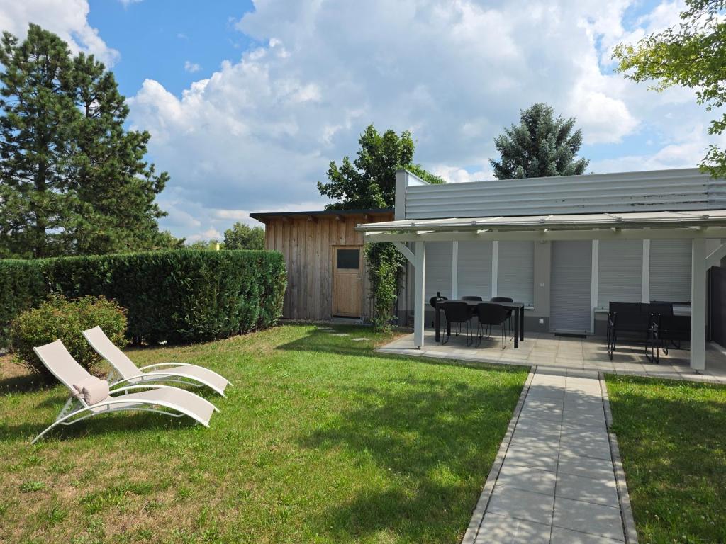 a pair of white chairs in the yard of a house at Ferienhaus in Kollm mitten in der Oberlausitz in Kollm