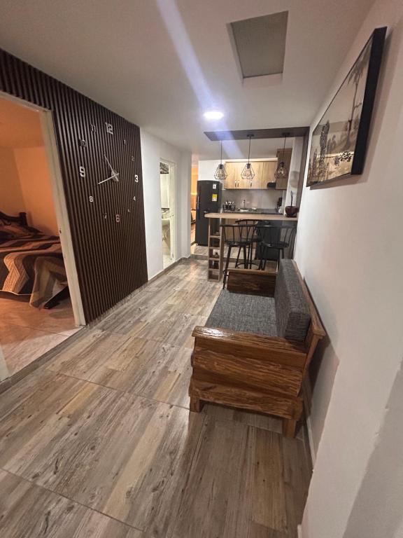 a living room with a wooden floor and a kitchen at Apartamento amoblado Chinchiná in Chinchiná