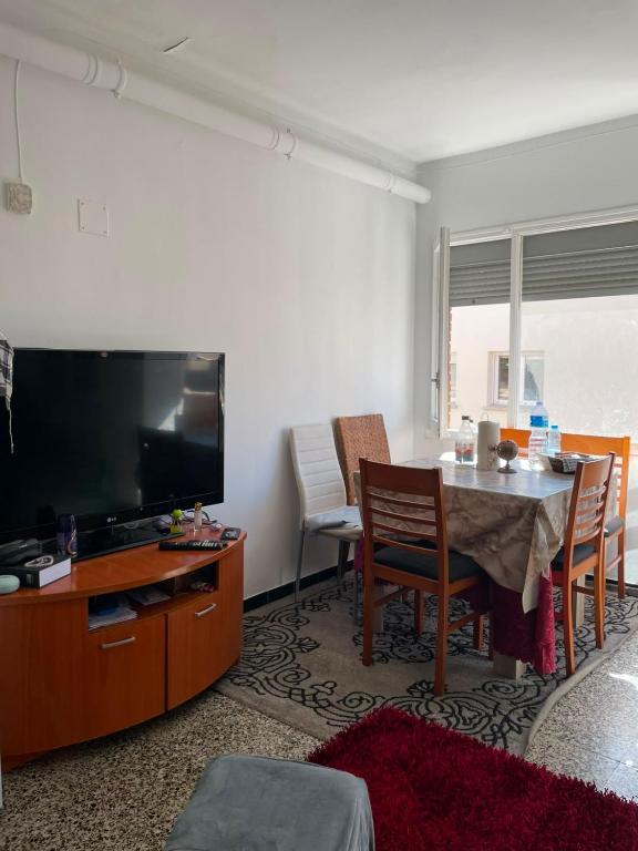 a living room with a table and a flat screen tv at Appartement in Girona