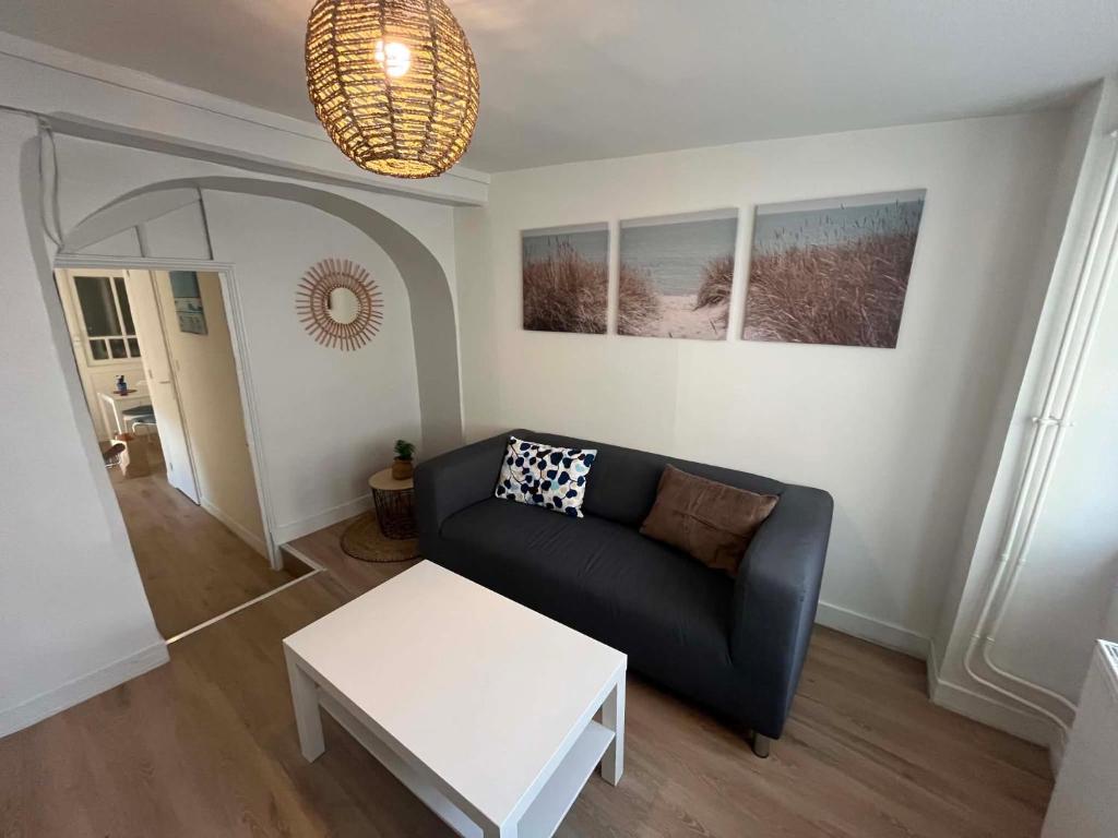 a living room with a couch and a table at L'écrin pure in Falaise