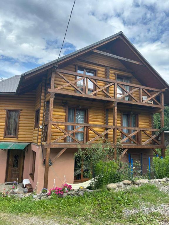 a large wooden house with windows at Gostynnyi Dvir u Marichky in Lazeshchyna