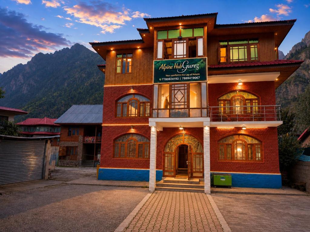 a building with a sign on the front of it at Alpine Hub Gurez in Wāmpor