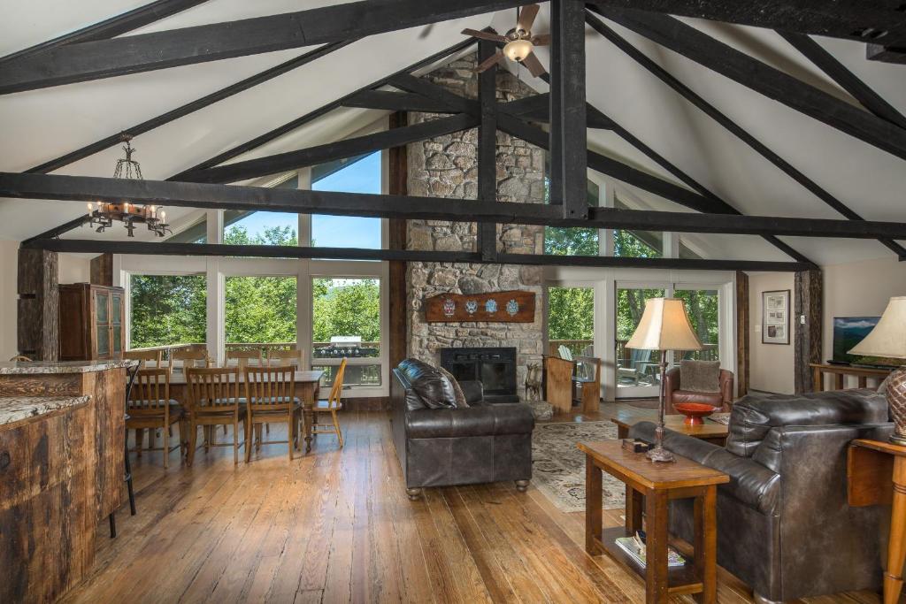 an open living room with a fireplace and a dining room at Majestic Mountain Haus in Beech Mountain
