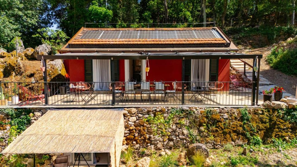 a red house with a roof with a porch at B&B I Menhir "nel Bosco" - Affittacamere in Lerici