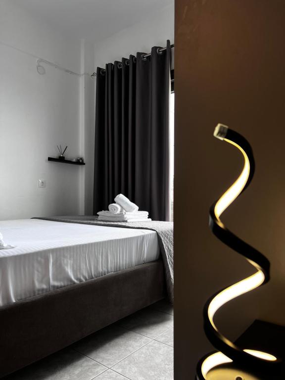 a bedroom with a bed and a black curtain at Uka apartment in Nea Irakleia