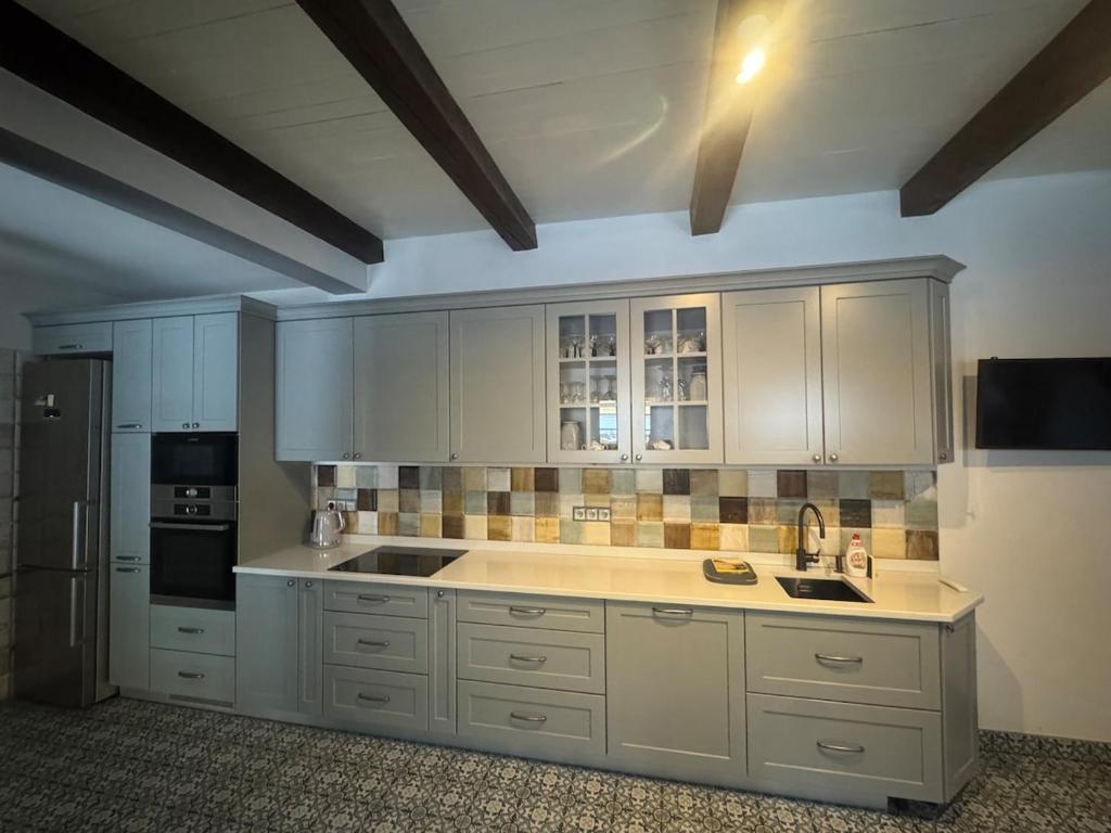 a large kitchen with white cabinets and a refrigerator at Чарунки днів in Mukacheve