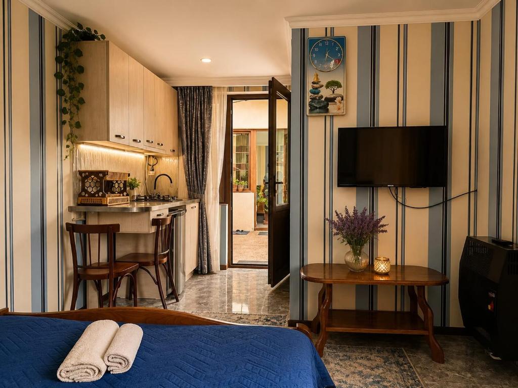 a bedroom with a bed and a kitchen with a counter at Guest house DAVID in Borjomi