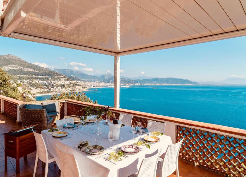 a table on a balcony with a view of the ocean at Villa Fuenti Bay - Amalfi Coast in Cetara