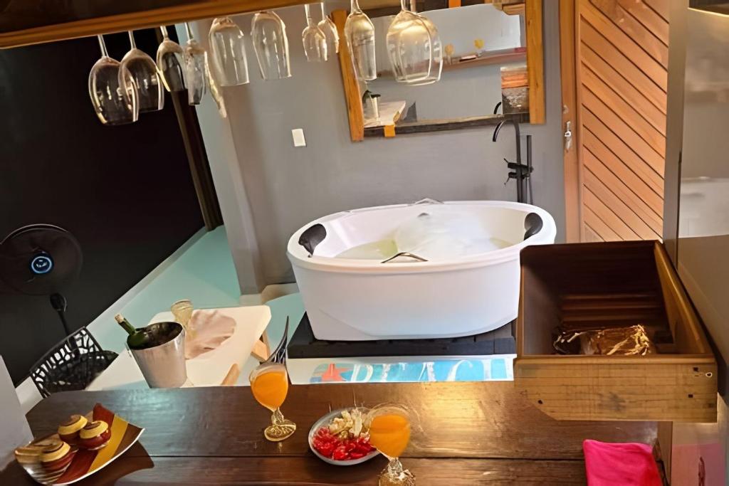 a bath tub sitting on top of a wooden table at Sossego Real: Casa Solo C/ Banheira Ofuro in Ilhabela