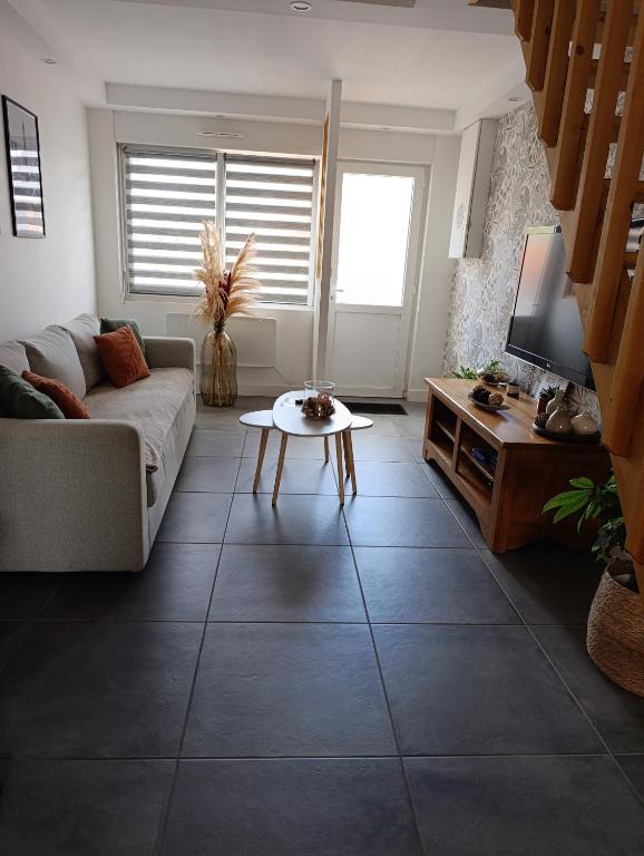 a living room with a couch and a table at La Pause Loonoise in Loon-Plage