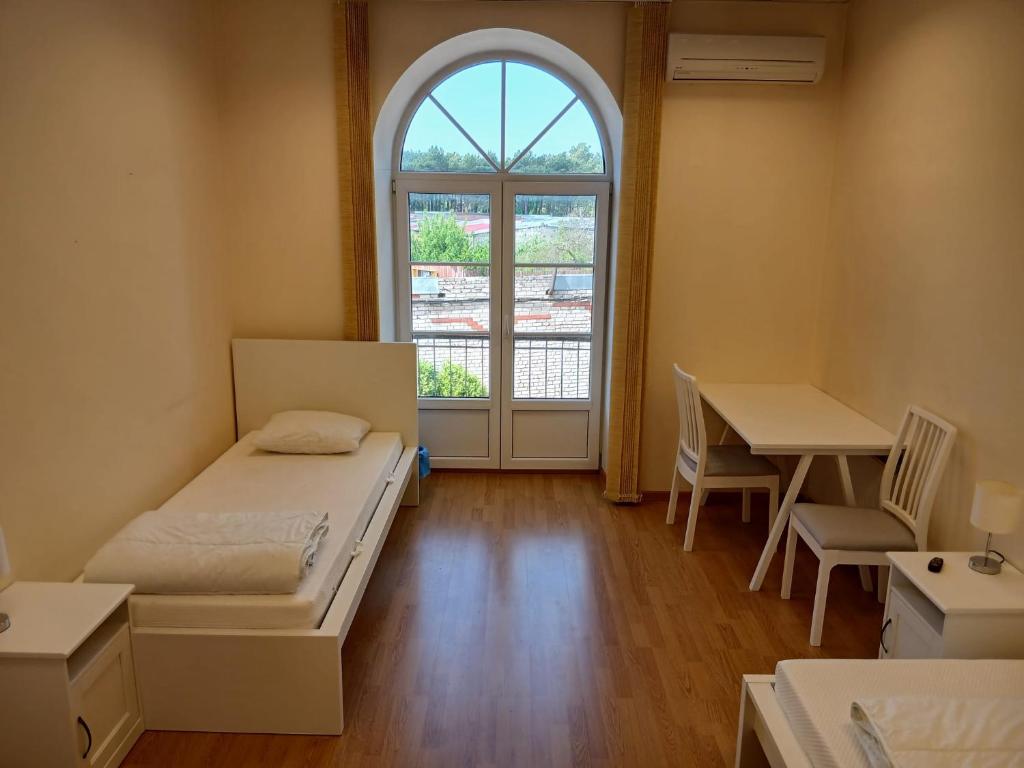 a room with a bed and a table and a window at Venta stay in Ventspils