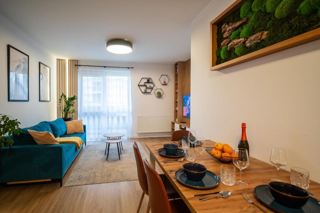 a living room with a table and a blue couch at JM Apartment in Poprad