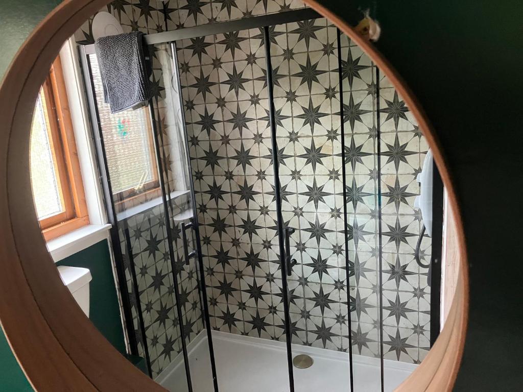 a bathroom with a shower with black and white tile at Vintage Retreat in Kingussie