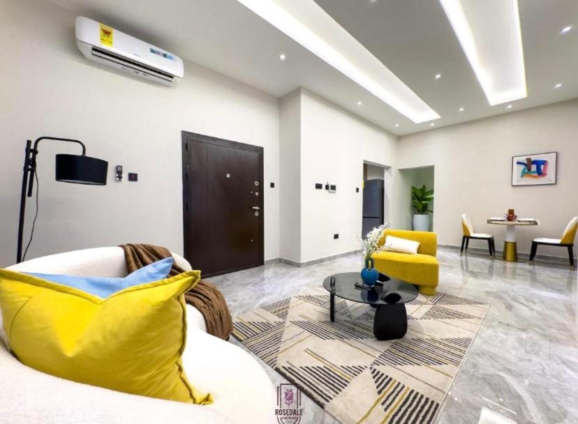 a living room with a yellow couch and a yellow chair at Rosedale luxury apartment in Ashouman