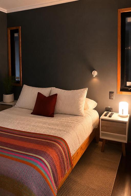 a bedroom with a bed with a black wall at Chagual Los Vilos Lodging in Los Vilos