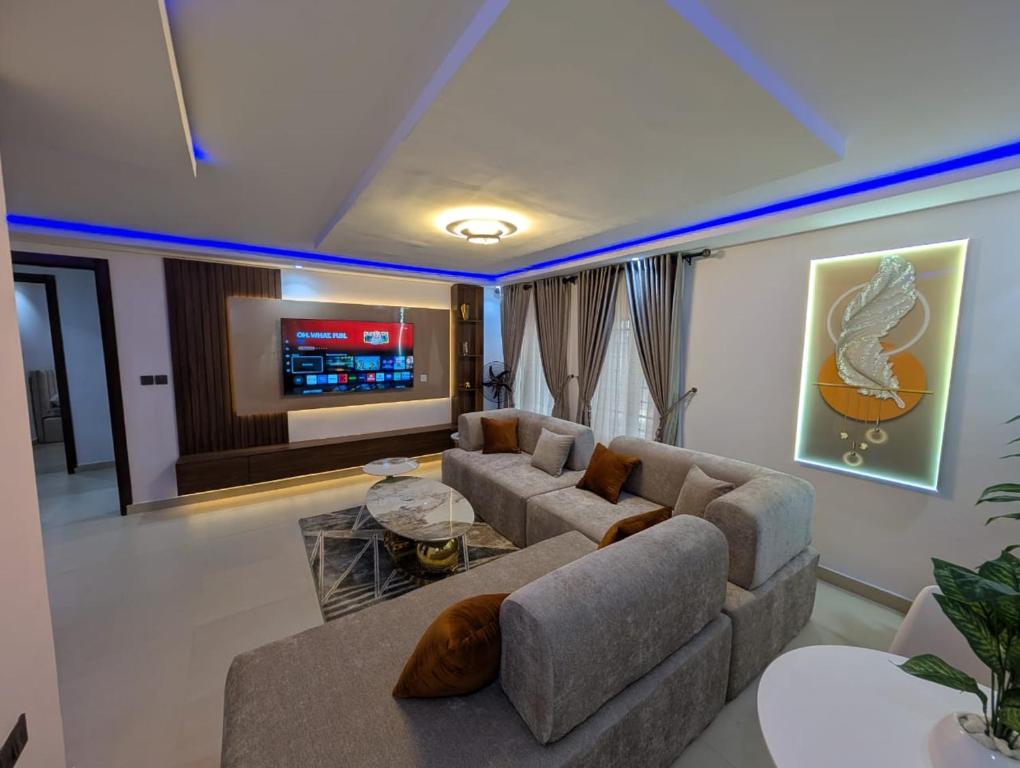 a living room with a couch and a tv at Kroft Residence in Lekki