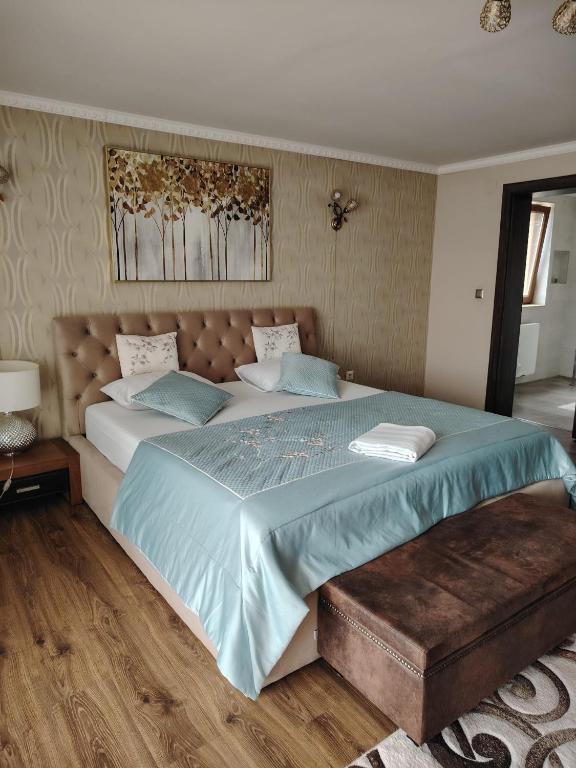 a bedroom with a large bed with a blue comforter at Casa Aura in Hunedoara