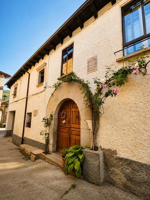 a brick building with a wooden door and flowers at Casa Rural Pablo in Ara
