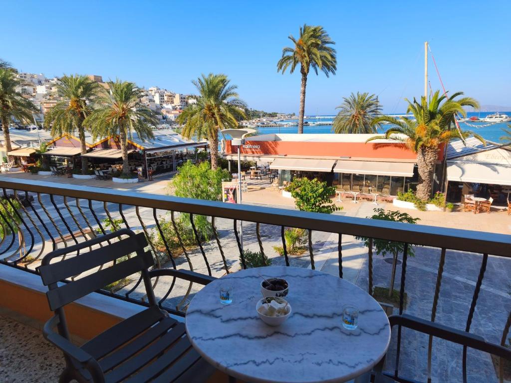 a table on a balcony with a view of a beach at SeaShell apartment Sea View, Castle View 200metres from the Beach in Sitia