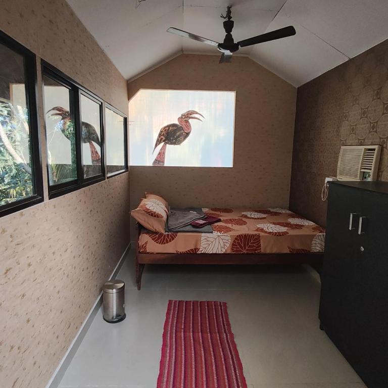 a bedroom with a bed with a painting of a bird at WeK Homes in Kumbla