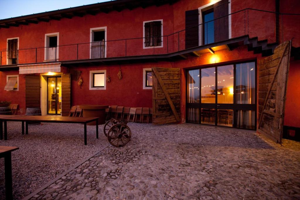 czerwony budynek ze stołem przed nim w obiekcie Agriturismo Frascje Dai Spadons w mieście Pradamano