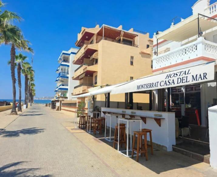 a restaurant with tables and chairs in front of a building at Montserrat Casa del Mar in Chipiona
