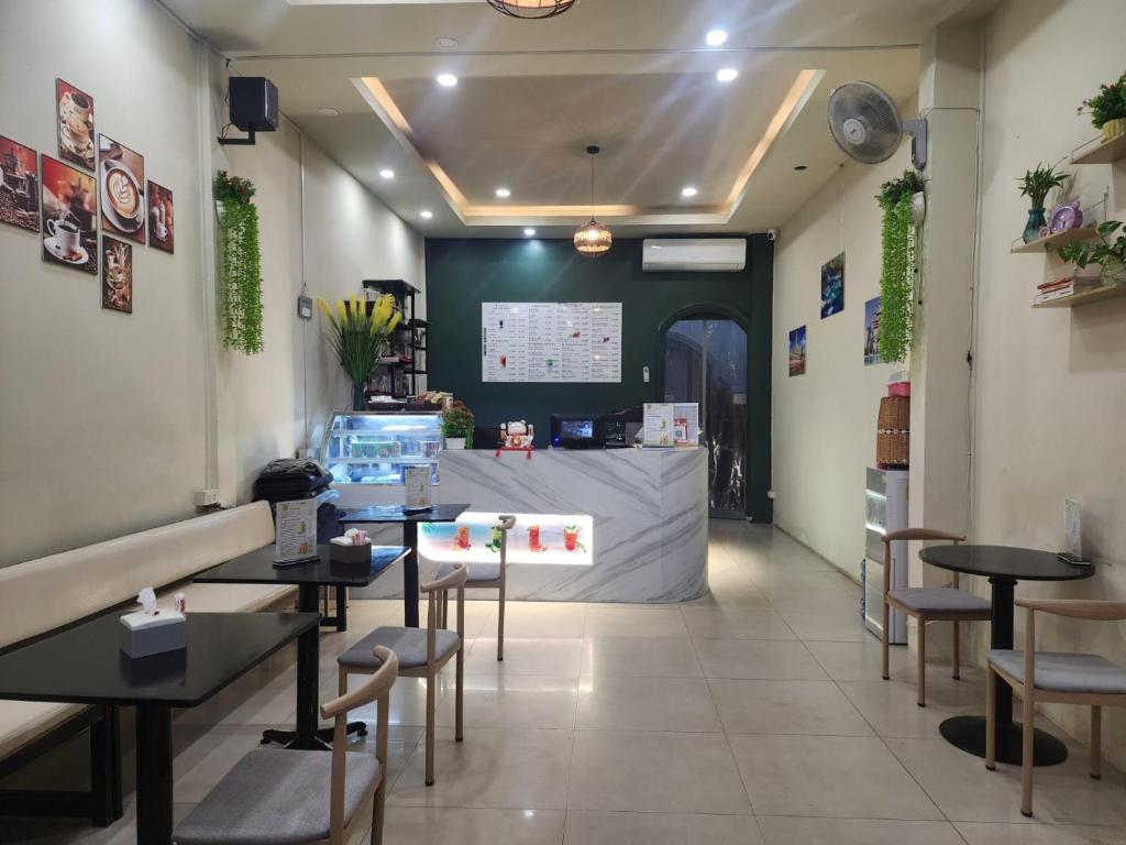 a restaurant with tables and chairs and a screen at Aroma Hostel in Vientiane
