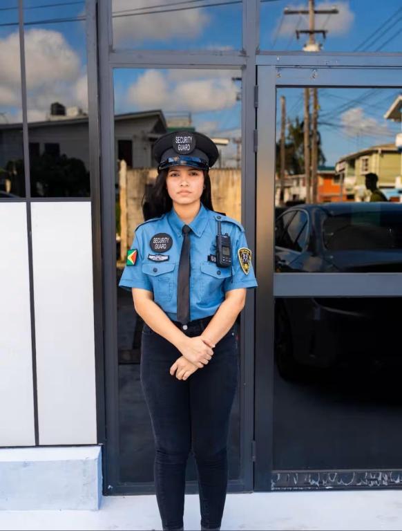 a woman in a police uniform standing in front of a building at Central Luxury Apartments in Georgetown